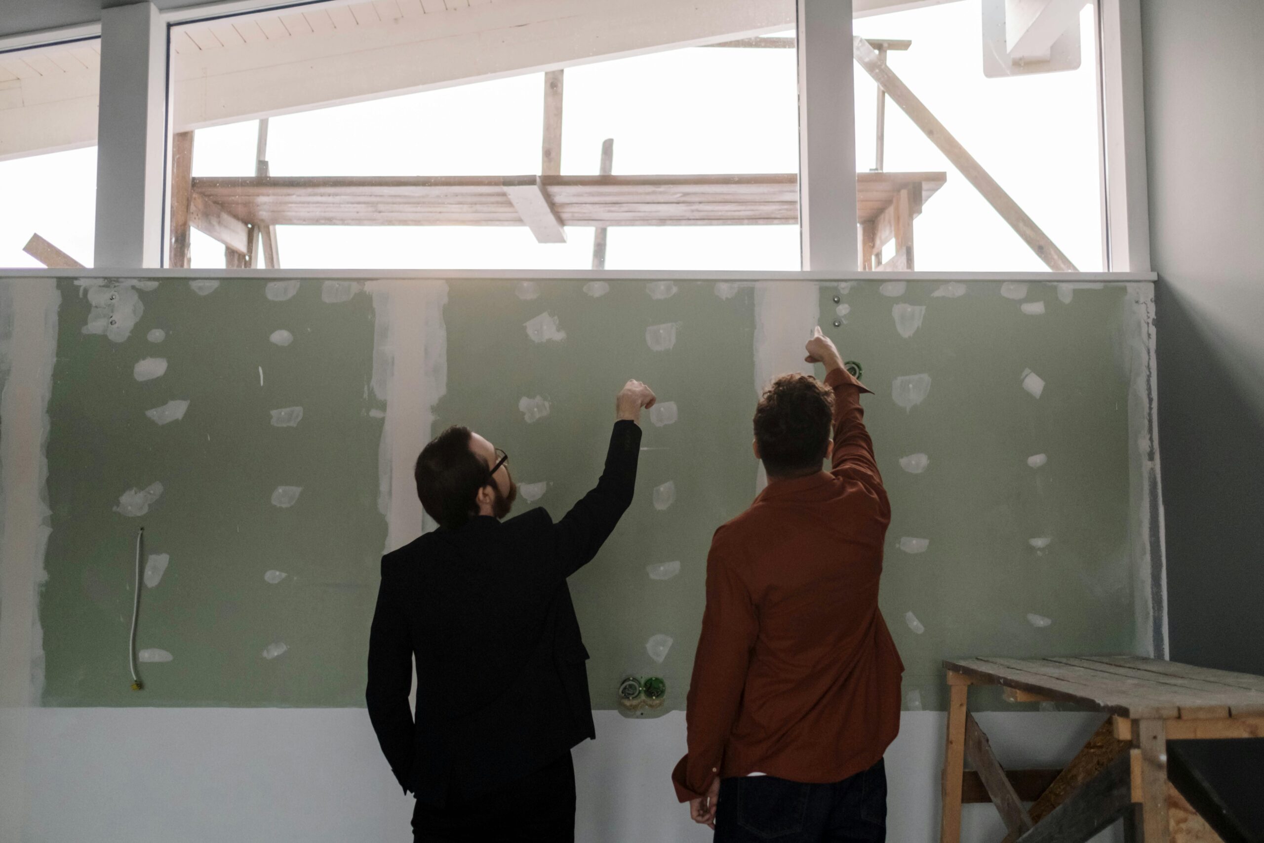 two people working together to repair a wall