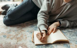 Thoughtful person reflecting quietly while journaling while considering therapy and emotional growth