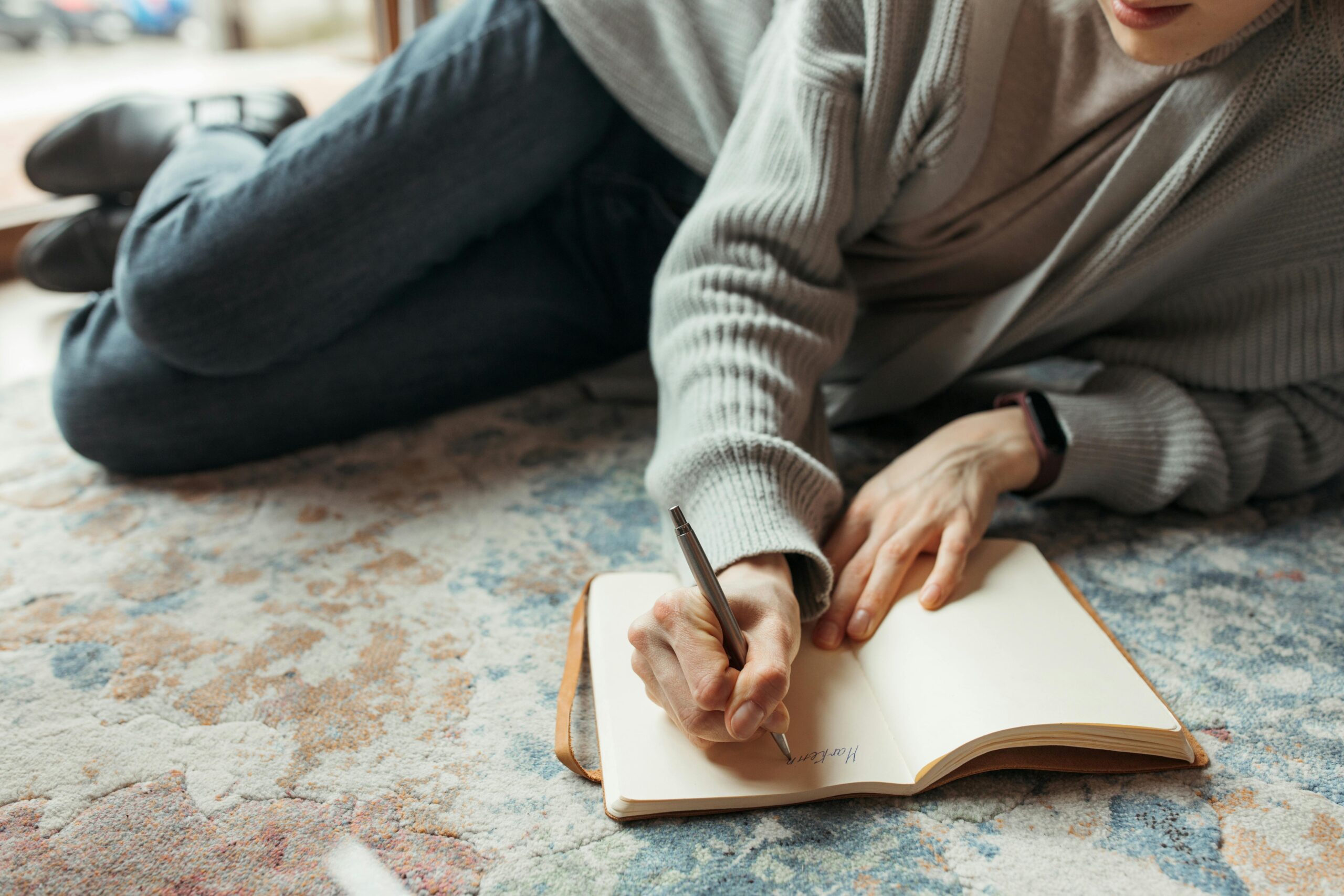 Thoughtful person reflecting quietly while journaling while considering therapy and emotional growth